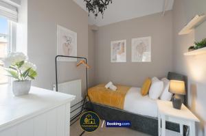 ein Schlafzimmer mit einem Bett und einem Tisch mit einer Lampe in der Unterkunft 4BR Contractor House by Townhouse Stays, Short Lets & Serviced Accommodation in Colchester Free Parking, Garden & WiFi in Lexden