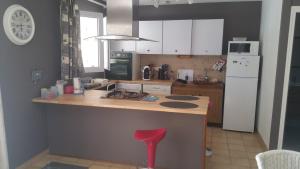 a kitchen with a counter with a red stool in it at Brétignolles-sur-Mer, maison bord de mer in Brétignolles-sur-Mer +9 photos