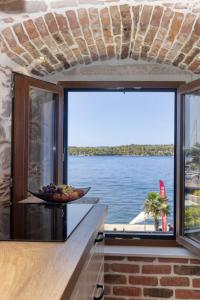 Apartman Sun 1 في شيبينيك: مطبخ مع نافذة كبيرة مطلة على الماء