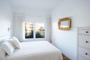 ein weißes Schlafzimmer mit einem Bett und einem Fenster in der Unterkunft Apartaments Marítim Torre Valentina in Sant Antoni de Calonge + 35 Fotos