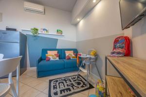 a living room with a blue couch and a table at Babyaccommodation Family Panoramic III in Pietra Ligure