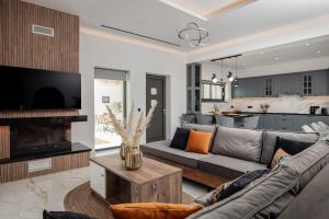 a living room with a gray couch and a tv at Villa Llaha Gabrijela - Luxurious Private Escape with Pool in Nature - By Villa Mana Gers in Gaïtánion