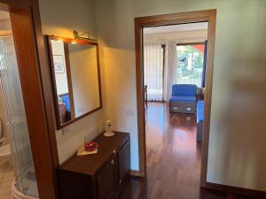 łazienka z lustrem oraz pokój ze stołem w obiekcie Apartment Giulia w mieście Muggia