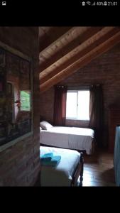 Un dormitorio con dos camas y una ventana. en Ananda Namahá, en Villa Ventana