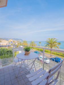 a balcony with a table and chairs and the ocean at Babyaccommodation Family Panoramic III in Pietra Ligure