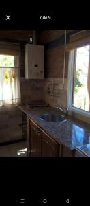 Una pequeña cocina con fregadero y ventana. en Ananda Namahá, en Villa Ventana