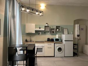 a kitchen with white appliances and a table and a refrigerator at Station Apartment EAST La Spezia - 5 terre in La Spezia