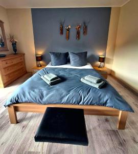 une chambre avec un grand lit avec une couverture bleue dans l'établissement Charmante, familienfreundliche Ferienwohnung im Herzen der Vulkaneifel, à Niederstadtfeld