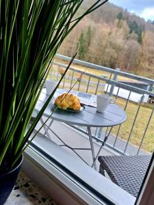 une table avec une assiette de nourriture sur un balcon dans l'établissement Charmante, familienfreundliche Ferienwohnung im Herzen der Vulkaneifel, à Niederstadtfeld
