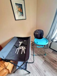 Cette chambre comprend une table, une chaise et un parasol. dans l'établissement Charmante, familienfreundliche Ferienwohnung im Herzen der Vulkaneifel, à Niederstadtfeld