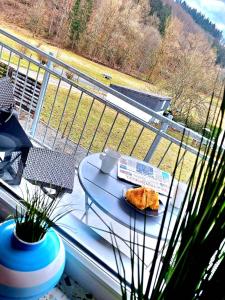 - une table avec une pâtisserie sur un balcon avec vue dans l'établissement Charmante, familienfreundliche Ferienwohnung im Herzen der Vulkaneifel, à Niederstadtfeld 33 autres photos