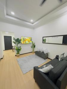 a living room with a black couch and a rug at 3Bedroom Landed Cozy Home Ipoh Netflix in Ipoh +30 photos