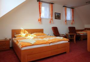 sypialnia z łóżkiem i 2 krzesłami w obiekcie Penzion Rakovec w mieście Bukovinka