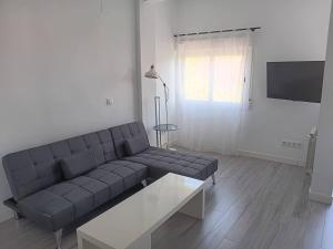 salon z kanapą i stołem w obiekcie Blue Loft Atocha w Madrycie