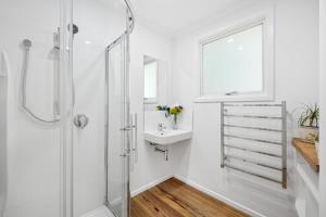 a white bathroom with a sink and a shower at Hagley Park South Queen size bedroom in Christchurch