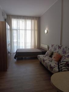 a living room with a couch and a bed at Festa Studio in Pomorie