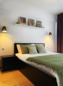 a bedroom with a large bed with green sheets at Musetesti Residential in Bucharest