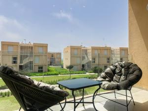 塔姆拉赫特乌兹达尔Luxurious Loft, Pool View的阳台上配有桌椅的露台