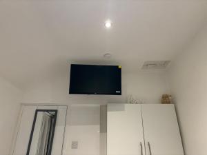 a flat screen tv on a wall above a refrigerator at West street home in Leek