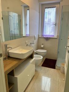 サン・ベネデット・デル・トロントにあるAppartamento Custozaの洗面台とトイレを備えた白いバスルーム
