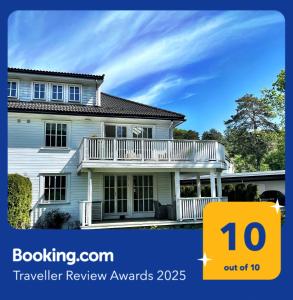 a white house with a porch and a sign that says buyer review awards at Comfortable living in Prestasen Park - only 500m to Sandefjord centre and the harbour, in Sandefjord