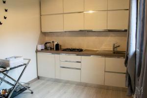 a kitchen with white cabinets and a sink at Trilocale sul Lungomare in Cannigione