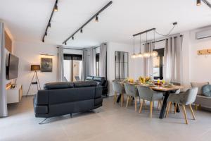 Una sala de estar y un comedor con mesa y sillas. en Luxury Villa Libellile, en San Miguel de Abona