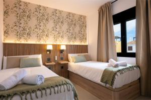 Un dormitorio con dos camas y una ventana. en Luxury Villa Libellile, en San Miguel de Abona