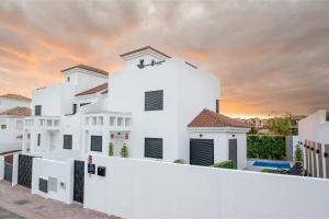una casa blanca con una puesta de sol en el fondo en Luxury Villa Libellile, en San Miguel de Abona