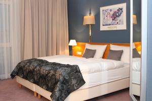 een slaapkamer met een groot bed met witte lakens bij Grunau Hotel in Bayreuth