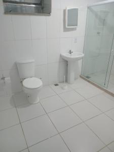 une salle de bain blanche avec toilettes et lavabo dans l'établissement Casa do Sossego, à Ilha do Frade