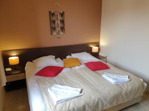 a bedroom with a bed with red and yellow pillows at Banderitsa Apartments by BookVillaBG in Bansko