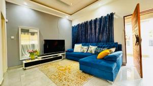 a living room with a blue couch and a tv at CBD sanctuary-self catering in Gaborone