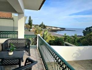 a balcony with chairs and a view of the ocean at Ocean Breeze in Ponta Delgada