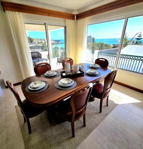 a dining room table and chairs with a view of the ocean at Ocean Breeze in Ponta Delgada