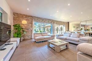 un soggiorno con divani e un muro di mattoni di La Villa des Légendes - Spa & Swimming Pool a Sizun