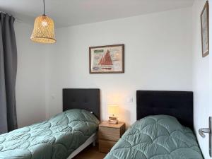 two beds sitting next to each other in a bedroom at Maison rénovée proche plages de Trégastel - FR-1-542-68 in Trégastel