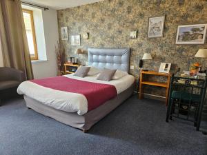 a bedroom with a large bed in a room at Logis Hôtel-Restaurant Le Val d'Amby in Hières-sur-Amby