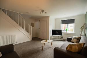 a living room with a couch and a tv at Babbage House By Horizon Stays in Stockton-on-Tees
