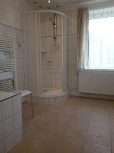a large bathroom with a shower and a window at Wohnung In Hänichen Mit Garten in Bannewitz +9 photos