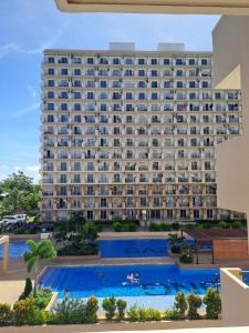 a large building with a pool in front of it at Paula' s cozy Haven in Lapu Lapu City