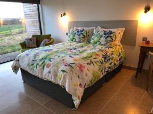 a bedroom with a bed with a floral comforter at Tweed Hideaway in Kelso