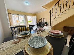 a dining room with a table with plates and wine glasses at Casa Brisa Mediterranea by Rental Hero in Los Alcázares
