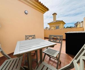a picnic table and chairs on a balcony with a building at Casa Brisa Mediterranea by Rental Hero in Los Alcázares +30 photos