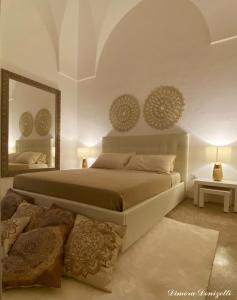 ein Schlafzimmer mit einem großen Bett und einem Spiegel in der Unterkunft Dimora Donizetti 5 in Carovigno