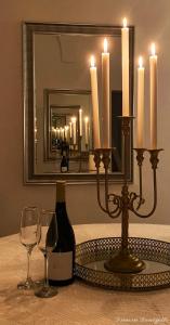 eine Flasche Wein auf einem Tisch mit Gläsern und Kerzen in der Unterkunft Dimora Donizetti 5 in Carovigno