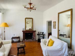 a living room with a white couch and a mirror at Maison centre village ZONZA in Zonza