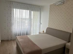a bedroom with a bed and a large window at Silver Apartman in Siófok