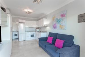 a living room with a blue couch and pink pillows at Brisas de Puerto Rico in Mogán