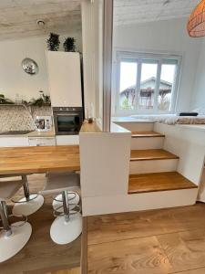 cocina con armarios blancos y escaleras en una habitación en Sainte Luce proche de La Loire, en Sainte-Luce-sur-Loire